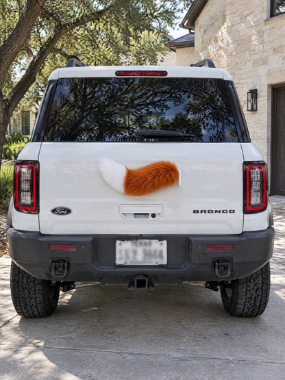 Orange & White | Wagride tail mounted at the rear of a parked car