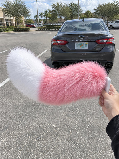 Pink & White | Wagride tail held in a hand in a parking lot