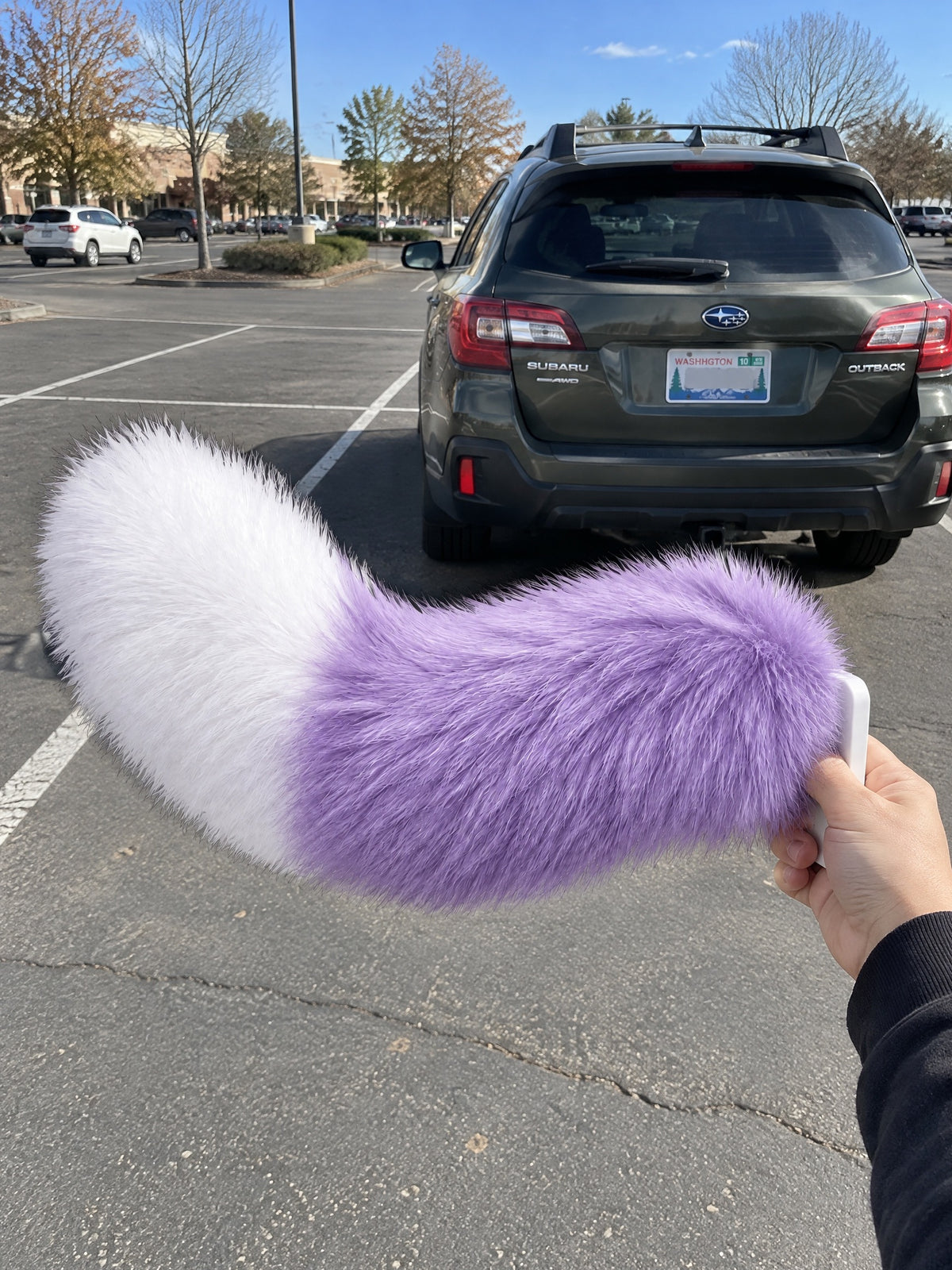 Purple & White | Wagride tail held in a hand in a parking lot